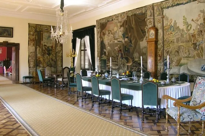 A castle dining room with tapestries and a long laid table