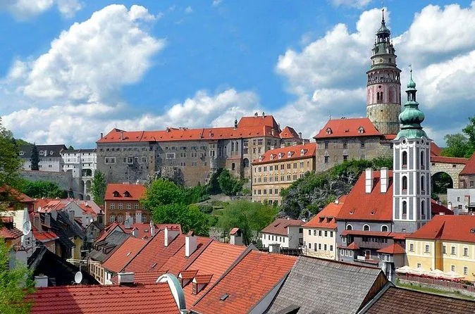 The castle tower and church above red roofs in Český Krumlov