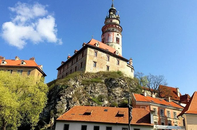 The painted castle tower of Český Krumlov above red roofs